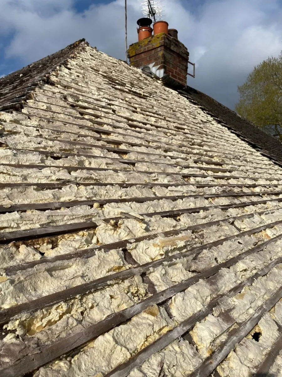 Spray foam insulation exposed under a stripped roof