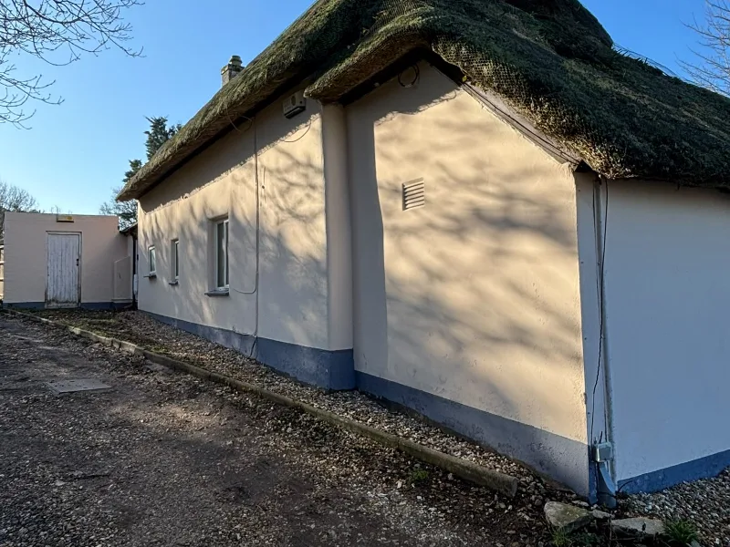 After: the cottage walls clean and freshly decorated, with a new painted plinth along the base